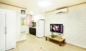 a living room with a tv on a wall at Chorok Pension in Boryeong