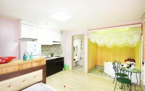 a kitchen with a table and a kitchen with a bathroom at Chorok Pension in Boryeong +1 photo