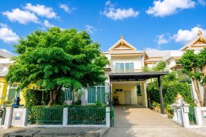 a house with a gate and a tree at Amphawan in Ban Nong Khrai Luang