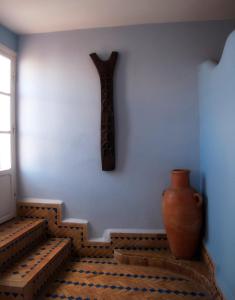 ein Zimmer mit einer Vase und einer Wand mit einem Kreuz in der Unterkunft Casa Lila & Spa in Essaouira