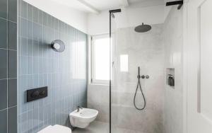 a bathroom with a shower and a toilet and a sink at Brixen City Maisonette in Bressanone