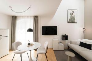 a white living room with a white couch and a table at Brixen City Maisonette in Bressanone