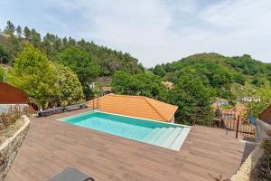 a swimming pool on top of a wooden deck at Casa Aurora in Campo do Gerês
