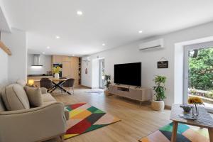 a living room with a flat screen tv and a couch at Casa Aurora in Campo do Gerês