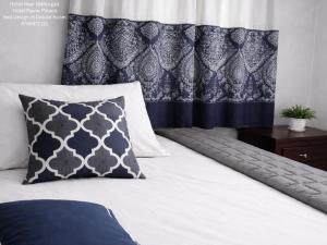 a bed with a blue and white pillow on it at Hotel Pawar Palace Mahurgad in Māhūr
