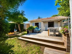 a backyard with a wooden deck with a table and chairs at Le COCON DU BASSIN in Arès