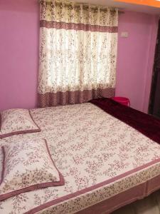 a bedroom with a bed with a curtain and a window at Hotel Pawar Palace Mahurgad in Māhūr