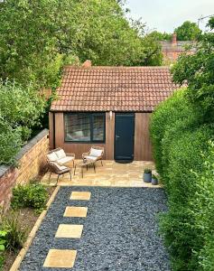a backyard with a shed with a bench and a chair at Kettering Railway Lodge in Kettering