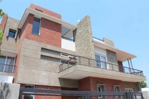 a building with a balcony on the side of it at Red Brick House in Panchkula