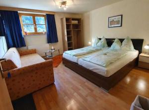 a bedroom with a large bed and a couch at Präau-Gut in Dorfgastein