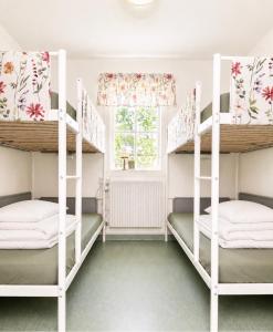 a bedroom with two bunk beds and a window at Valla Vandrarhem in Linköping