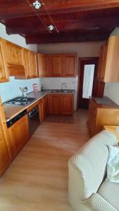 a kitchen with wooden cabinets and a stove top oven at Casa della Mamma in Antey-Saint-André