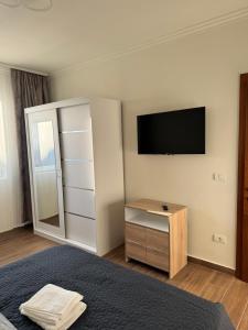 a bedroom with a television and a dresser with a mirror at Lucas&Timeea in Caransebeş