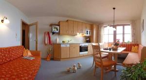 a living room with a couch and a table and a kitchen at Präau-Gut in Dorfgastein +13 photos