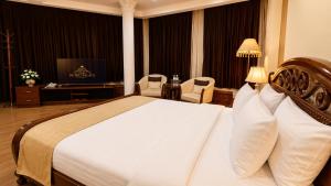 a hotel room with a bed and chairs and a television at Retro Palace Residence Tashkent in Toshkent-Passajir Bekati