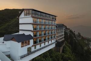 a building with windows on the side of a mountain at Hotel The Bliss Kufri in Kūfrī