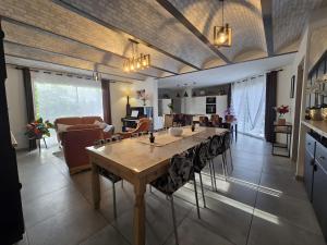 a kitchen and living room with a large wooden table at Superbe villa avec piscine in Bras