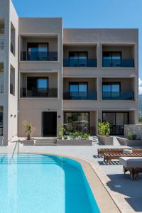 an exterior view of a building with a swimming pool at Stella Maria Hotel & Suites in Malia