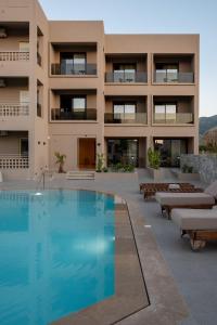 a building with a swimming pool in front of a building at Stella Maria Hotel & Suites in Malia