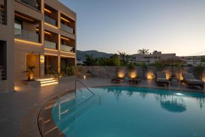 a large swimming pool next to a building at Stella Maria Hotel & Suites in Malia