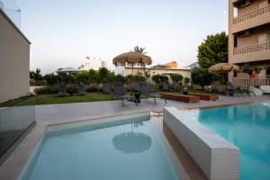 a swimming pool in front of a building at Stella Maria Hotel & Suites in Malia +137 photos