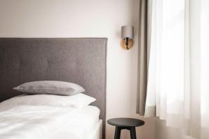 a bedroom with a bed with white pillows and a table at Brixen City Maisonette in Bressanone +20 photos