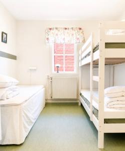 a bedroom with two bunk beds and a window at Valla Vandrarhem in Linköping