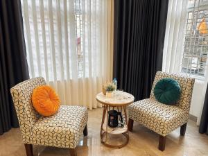 two chairs and a table in a room at Bi Room in Hai Phong