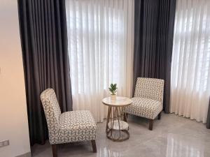 two chairs and a table in a room with a window at Bi Room in Hai Phong