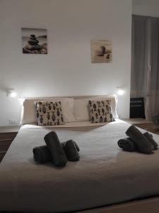 a white bed with three black pillows on it at Petriccioli seaview in Lerici