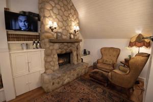 a living room with a stone fireplace and a chair at Simpson House Inn in Santa Barbara