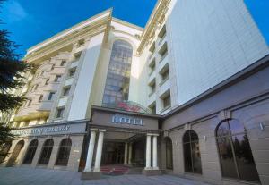 a building with a hotel on top of it at Grand Voyage Hotel in Almaty