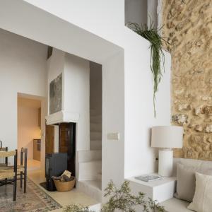 a living room with white walls and a stone wall at Casa Felicita in Casas de Pradas