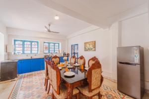 a kitchen with a table and chairs and a refrigerator at La casa Verde 4BHK with Private Pool, Baga in Baga
