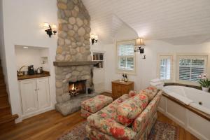 a living room with a fireplace and a couch and a tub at Simpson House Inn in Santa Barbara
