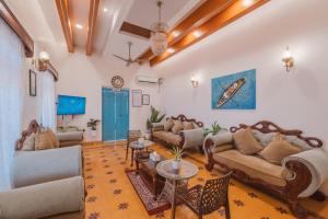 a living room with couches and tables at La casa Verde 4BHK with Private Pool, Baga in Baga