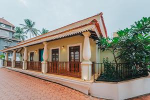a yellow house with a balcony with a fence at La casa Verde 4BHK with Private Pool, Baga in Baga