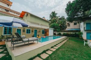 a backyard with a swimming pool and a house at La casa Verde 4BHK with Private Pool, Baga in Baga
