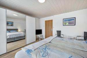 a bedroom with a large bed and a television at Ferienhaus Plüschenworth in Drochtersen