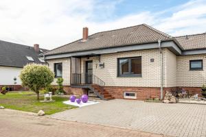 a house with purple balls on a driveway at Ferienhaus Plüschenworth in Drochtersen