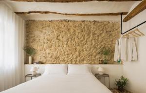 a bedroom with a white bed and a wall at Casa Felicita in Casas de Pradas +18 photos
