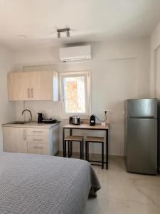 eine Küche mit Spüle, Kühlschrank und Tisch in der Unterkunft Theta Project in Stavros