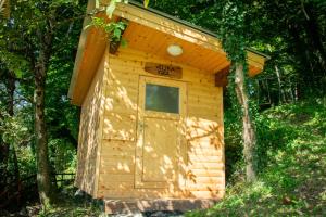 a small wooden out house with a door at Glamping Zeleni raj Vače in Vače