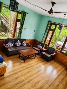 a living room with a couch and a table at Adarsh homestay - 1BHK in Manāli