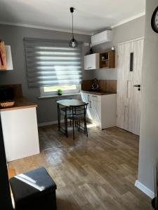 a small kitchen with a table and a window at W sosnowym lesie 2 in Lubniewice