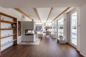 a living room with white furniture and large windows at DACHJUWEL Luxus - Apartment Penthouse Ferienwohnung in Leibnitz
