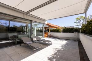 a patio with two chairs and a table and some windows at DACHJUWEL Luxus - Apartment Penthouse Ferienwohnung in Leibnitz
