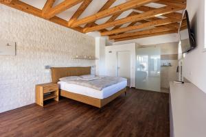 a bedroom with a bed and a wooden floor at DACHJUWEL Luxus - Apartment Penthouse Ferienwohnung in Leibnitz