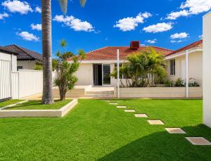 a yard with green grass and a house at Light-Filled Modern Home 3BR Pet-Friendly 5km-CBD in Perth