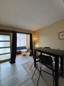 a living room with a table and chairs and a couch at Douglas in Saint Malo +3 photos